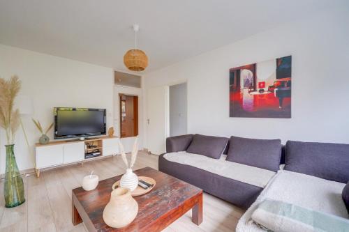 un salon avec un canapé et une télévision dans l'établissement Appartement très charmant à Bordeaux avec Parking, à Bordeaux