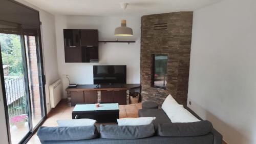 a living room with a couch and a tv at Piso rural Sol Berguedà in Aviá