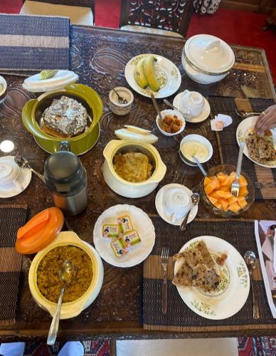 a table topped with plates of food on top at Dilnaaz group of houseboats in Srinagar