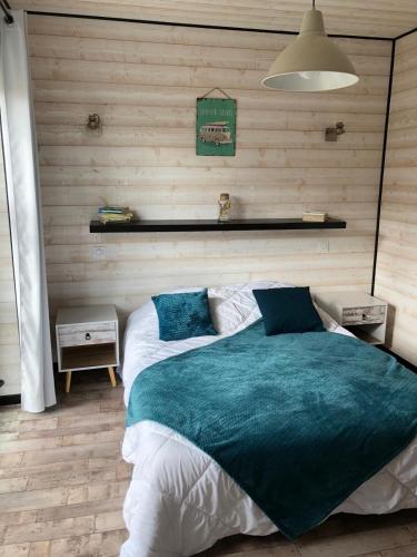 une chambre avec un grand lit avec une couverture bleue dans l'établissement La Casa Azul, à LʼAmélie