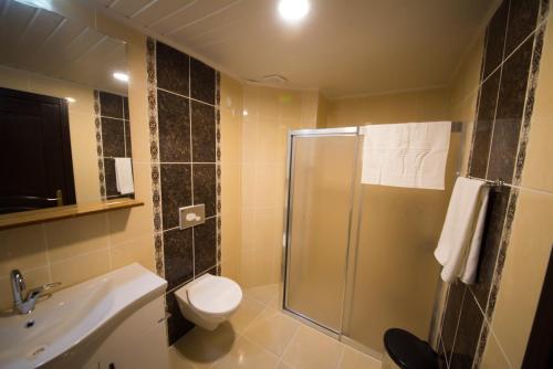 a bathroom with a shower and a toilet and a sink at Osmaniye Hanedan Otel in Osmaniye