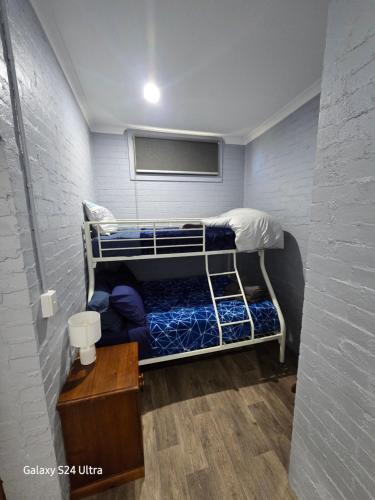 a small room with a bunk bed and a table at Ned's Servo in Dunolly