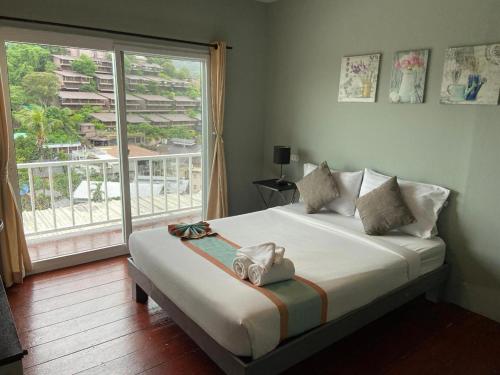 a bedroom with a bed and a large window at Uphill Cottage in Phi Phi Islands