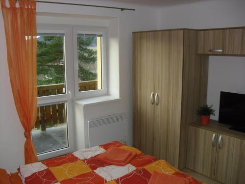 a bedroom with a bed and a window at Apartmán Linda in Lipno nad Vltavou