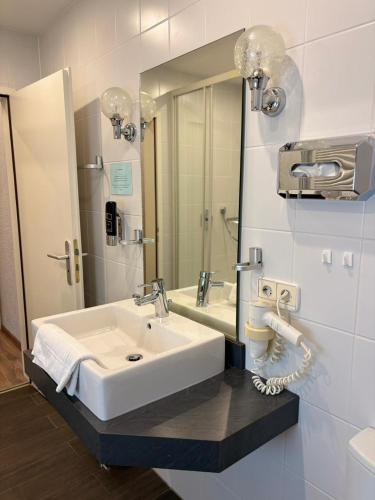 a bathroom with a white sink and a mirror at Landhotel Traube in Baden-Baden