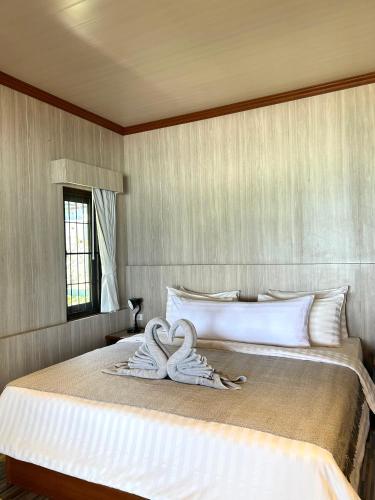a bed with two white towels on top of it at Kai Bae Beach Resort Koh Chang in Ko Chang