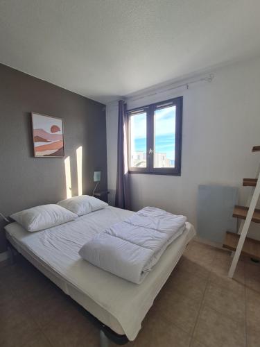 圣西普里安MAGNIFIQUE vue mer pour ce T2 avec piscine的卧室里有一张白色的床，还有一扇窗户