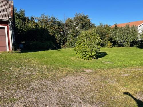 a yard with a house and a green field at Villa Madame in Väderstad