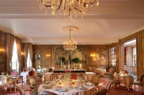 a dining room with tables and chairs and a chandelier at La Chartreuse Du Val Saint Esprit in Gosnay