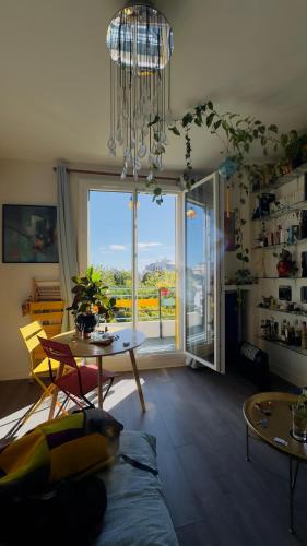un salon avec une grande fenêtre et un lustre dans l'établissement Canopée, paisible, chaleureux, lumineux, balcon, à Paris