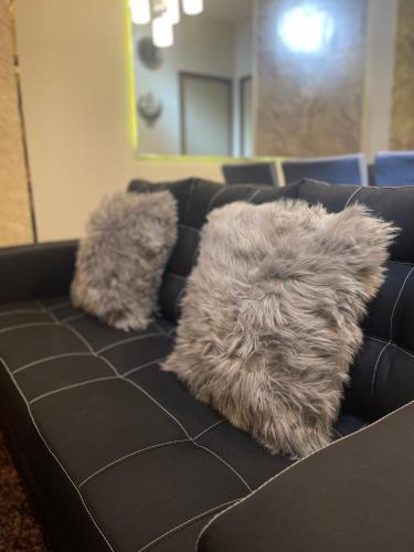 a black couch with a furry pillow on it at Two Bedroom with Balcony 70sqm -Pasig in Manila
