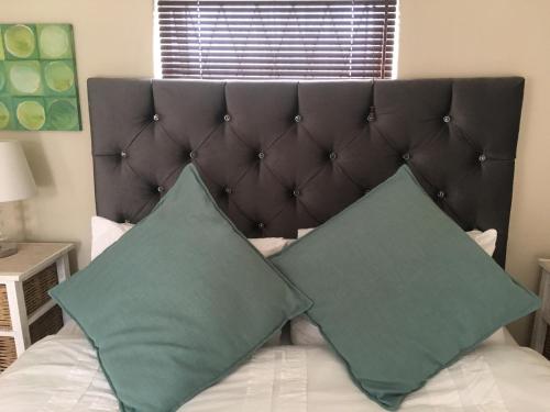 two green pillows sitting on top of a bed at Walmer Heights Guest House in Port Elizabeth