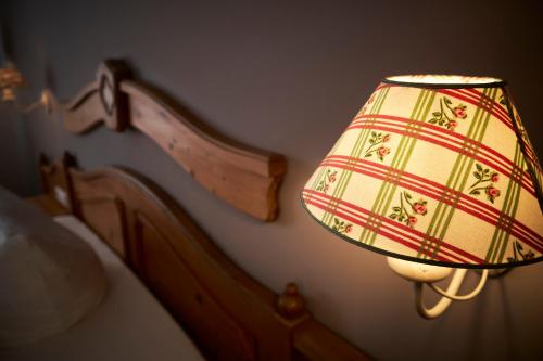 a lamp with a plaid shade next to a bed at Landhotel Traube in Baden-Baden