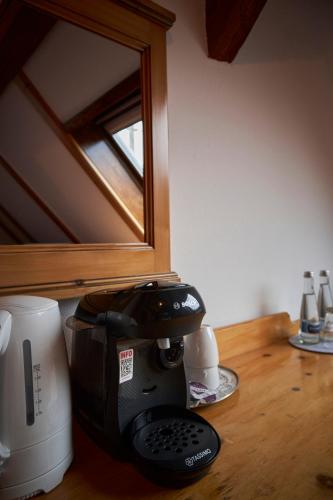 a coffee maker on a wooden counter with a mirror at Landhotel Traube in Baden-Baden