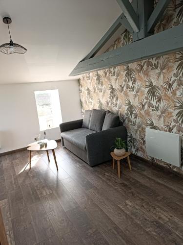 un salon avec un canapé et une table dans l'établissement La Rochette - Appartement, à Les Clouzeaux