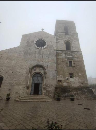 an old stone building with a clock on it at All'Arco Casa Vacanza in Acerenza
