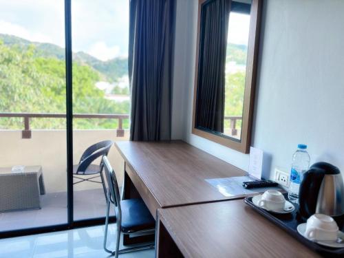 a desk in a room with a large window at patong v hotel in Patong Beach