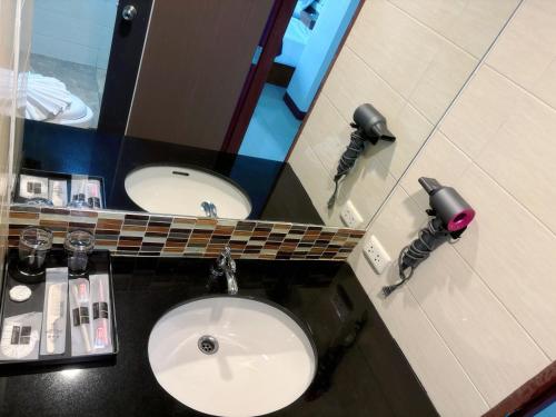 a bathroom with a sink and a mirror at patong v hotel in Patong Beach