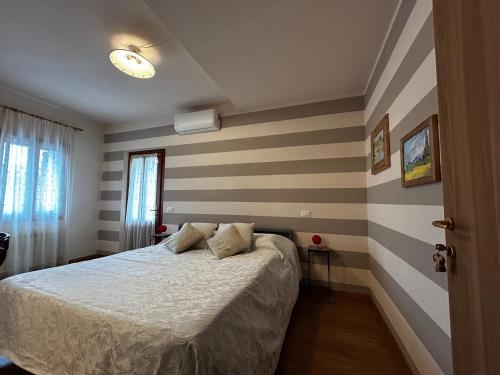 a bedroom with a bed and striped walls at B&B Casa del Conte in Farra di Soligo