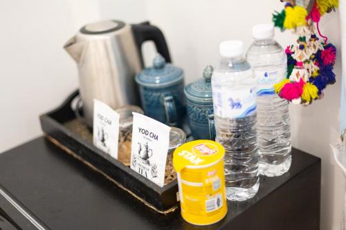 a table with a tray with water bottles on it at Pran At Kumuang Boutique House in Chiang Mai