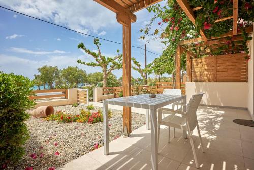 a table and chairs on a patio with a pergola at Votsalo in Ierápetra