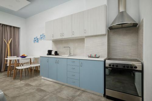 a kitchen with white cabinets and a sink and a stove at Votsalo in Ierápetra