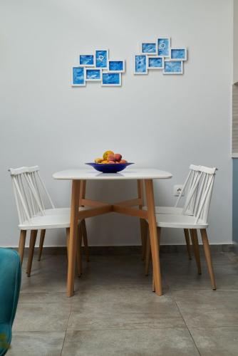 a table and two chairs with a bowl of fruit on it at Votsalo in Ierápetra