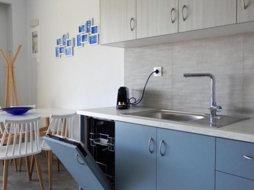 a kitchen with a sink and a table with chairs at Votsalo in Ierápetra