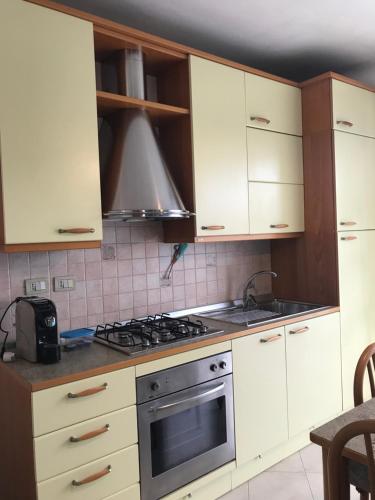 里米尼Appartamento per relax的厨房配有白色橱柜和炉灶烤箱