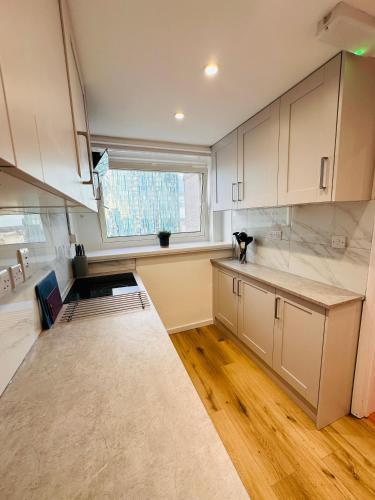 a kitchen with white cabinets and a window at Newly Renovated Private and Modern Shared Apartment, Each with Kitchenette, Central Birmingham RB in Birmingham