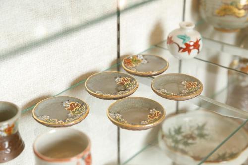 a glass shelf filled with bowls and vases at Inuyama Miyako Hotel in Inuyama