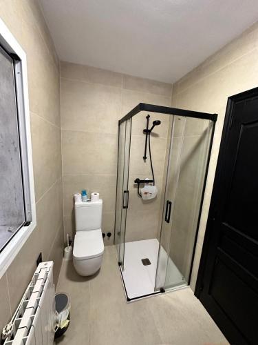 a bathroom with a toilet and a glass shower at Casa El Mirador in Calpe