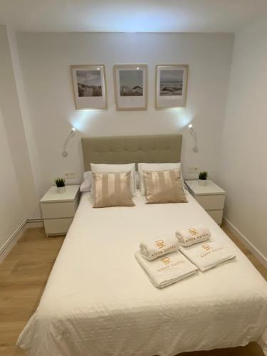 una camera da letto con un letto con due asciugamani sopra di Apartamento de lujo River Suites a Santander