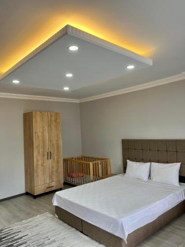 a bedroom with a large white bed and a cabinet at Ozn Suit Airport Hotel in Arnavutköy
