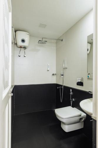 a bathroom with a toilet and a sink at The Nook Home in Ernakulam