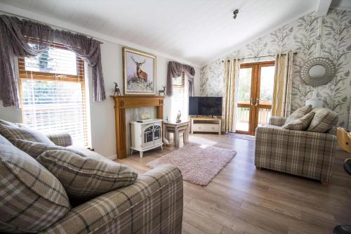 a living room with two couches and a tv at Stunning Lodge With Free Wifi For Hire At Carlton Meres In Suffolk Ref 60013M in Saxmundham