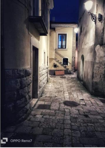 an empty alley with a building and a window at night at All'Arco Casa Vacanza in Acerenza