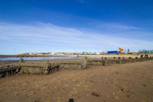 a beach with a wooden pier and the ocean at Wonderful 6 Berth Caravan For Hire At Manor Park, Hunstanton, Norfolk Ref 23028S in Hunstanton