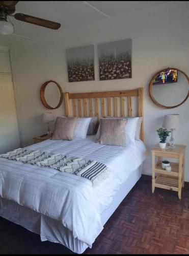 1 dormitorio con 1 cama grande y 2 espejos en la pared en Alu Guesthouse, en Roodepoort
