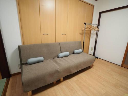 a couch with two pillows on it in a room at KENKOU Room -健康ルーム 大阪- in Osaka