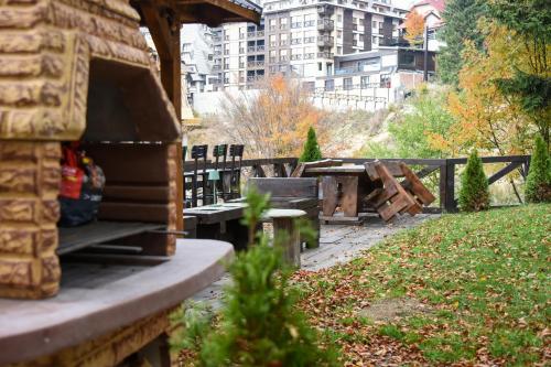 a picnic table and benches in a park at Vikendica Čeperković #1 in Kopaonik