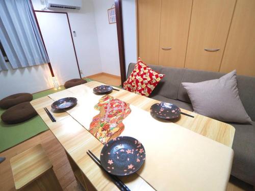 a table with plates and chopsticks on top of it at KENKOU Room -健康ルーム 大阪- in Osaka