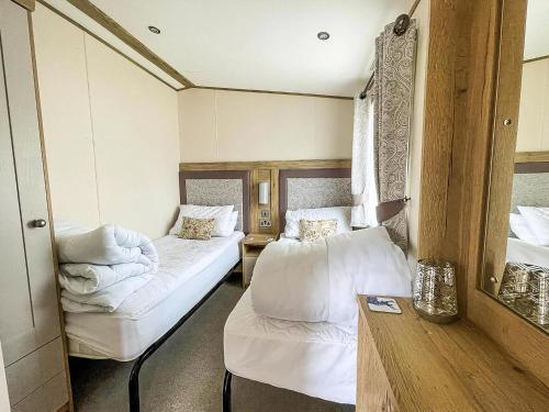 a small room with two beds and a mirror at Modern Caravan With Large Decking Area, Ref 60057Ch in Saxmundham
