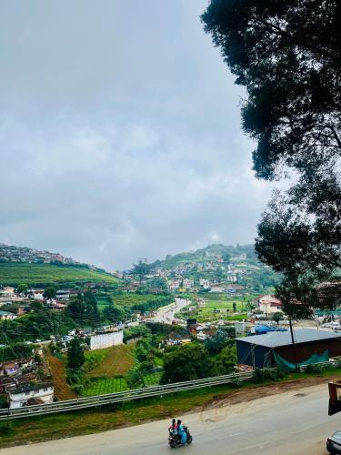 a group of people riding a motorcycle down a road at Violet Residency Ooty in Ooty