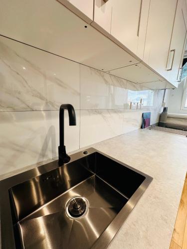 a kitchen sink with a faucet on top of it at Newly Renovated Private and Modern Shared Apartment, Each with Kitchenette, Central Birmingham RC in Birmingham