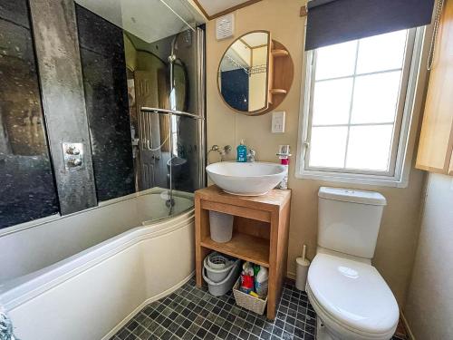 a bathroom with a sink and a toilet at Lovely Caravan With Large Decking At Naze Marine Holiday Park Ref 17306Br in Walton-on-the-Naze