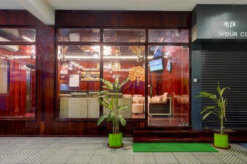 a store front with two potted plants in front of it at Super Townhouse NK Vivanta Luxury Rooms in Chennai
