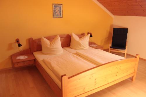 a bedroom with a wooden bed with white pillows at Familienferienhof Kroner in Zwiesel