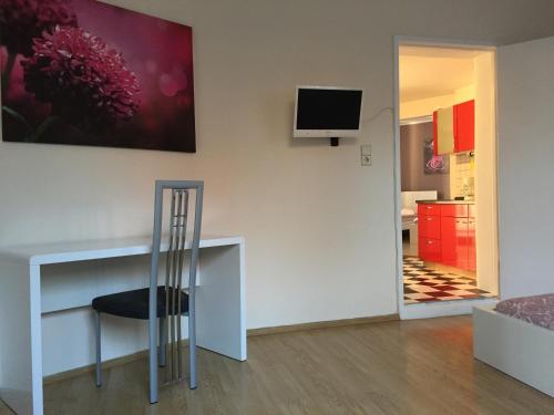 a room with a chair and a television on a wall at Ela Apartments Berlin in Berlin