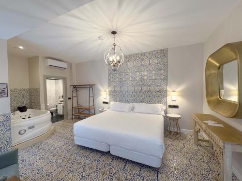 ein Schlafzimmer mit einem weißen Bett, einer Badewanne und einem Waschbecken in der Unterkunft Akla Hotel Badajoz in Badajoz